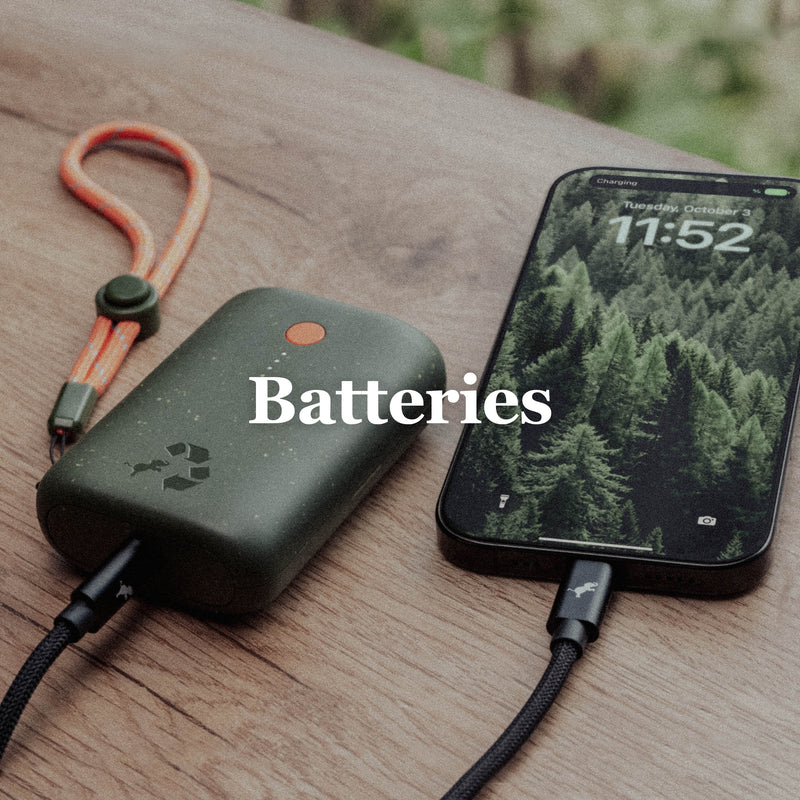 Image of Champ Portable Charger connected to iPhone with black cable on wood bench and greenery in background. Batteries text overlay.